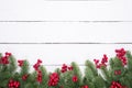 Christmas and New Year`s composition. Top view of spruce branches, pine cones, red berries and bell on white wooden table Royalty Free Stock Photo