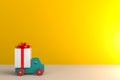 Gift box with red ribbon and car on wood table, White gift box on yellow wall background with space Royalty Free Stock Photo