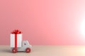 Christmas and New Year`s Day, Gift box with red ribbon and car on wood table, White gift box on pink wall background with space Royalty Free Stock Photo