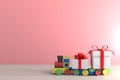 Gift box with red ribbon and train on wood table, White gift box on pink wall background with space, 3d rendering Royalty Free Stock Photo