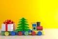 Christmas and New Year`s Day, Christmas gift and train on wood table, White gift box on yellow wall background with space