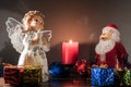 Christmas or new year`s eve. Angel and Santa Claus with gifts at night on the background of a lit candle. New year holiday Royalty Free Stock Photo