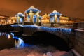 Christmas and New Year street decoration on bridge with pavilions with small domed caps, lights and river, St. Petersburg, Russia.