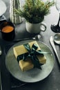 Christmas or New Year Table Setting. Craft blue plate with cutlery and gift box, fir tree branches Royalty Free Stock Photo