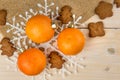 Christmas or New Year tangerines and gingerbread cookies with snowflakes framed on brown sack background texture.