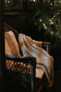 christmas and new year time. cozy armchair or wicker easy chair with a comfy knitted plaid and a fur pad pillow Royalty Free Stock Photo