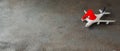 Christmas or New Year travel concept. Toy airplane and Santa Claus hat. Christmas traveling baner