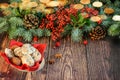 Christmas and New Year vignette of branches of blue fir, pinecones, red berries and wooden plate full of cookies. Christmas nad