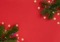 Christmas, New Year or winter red background with fir tree branches, gold stars and lights. Xmas and New Year holiday concept. Royalty Free Stock Photo