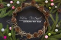 Christmas wreath decoration cone, fir-tree branches, colorful glass balls on black background. Top view. Royalty Free Stock Photo