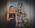 Christmas night, a beautiful girl in a black dress with a glass of wine. Royalty Free Stock Photo