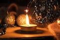 Christmas night still life, Blurred glowing small candle and christmas decoration toys