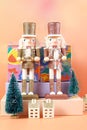 Christmas nutcracker ornaments and gifts against a modern coral background. Royalty Free Stock Photo