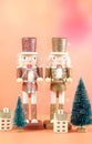 Christmas nutcracker ornaments and gifts against a modern coral background. Royalty Free Stock Photo