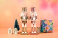 Christmas nutcracker ornaments and gifts against a modern coral background. Royalty Free Stock Photo