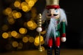 Christmas nutcracker wooden figure, toy soldier decoration with tree lights bokeh.