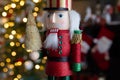 Christmas nutcracker wooden figure, toy soldier decoration with tree lights bokeh. Royalty Free Stock Photo