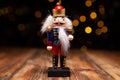 Christmas nutcracker wooden figure, toy soldier decoration with tree lights bokeh.