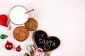 Christmas oatmeal cookies and glass of milk for Santa Claus on white background top view. Christmas greeting card with