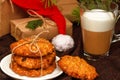 Christmas oatmeal cookies, transparent mug of coffee or cappuccino, gift boxes in kraft paper, a hat of Santa Claus