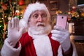 Christmas online congratulations from Santa. Surprised Santa Claus using mobile phone for distance Christmas call people