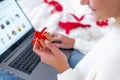 Christmas online shopping. Female buyer makes order on laptop. Woman buy presents, prepare to xmas, among gift boxes and Royalty Free Stock Photo