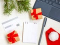 Christmas online shopping flat lay. Notebook and pen. Credit card, Laptop, gifts Royalty Free Stock Photo