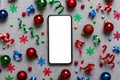 Christmas online shopping from home phone with blank white display top view. smart mobile with copy space on colored