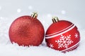 Christmas Ornaments over Bokeh Background. Red Christmas balls on snow during a snowfall, against a background of silver bokeh. Royalty Free Stock Photo