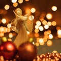 Christmas ornaments and straw angel lying on balls of a Christmas chain on a blurred background with lights Royalty Free Stock Photo