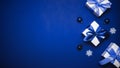 Christmas ornaments. White gift box with cyan ribbon, New Year balls and winter tree in xmas composition on dark blue background Royalty Free Stock Photo