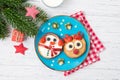 Christmas pancakes in a shape of deer and snowman made of fresh fruits and berries and glass of milk. Healthy food for kids ideas Royalty Free Stock Photo