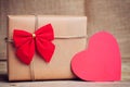 Christmas paper box with heart decoration on wooden surface