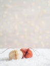 Christmas paper origami decor in the foreground in artificial snow and a blurred background with a glowing garland