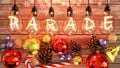 Christmas Parade - cozy wooden table with xmas ornaments with cones, candy cane, shiny balls and warm incandescent bulb lights