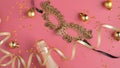 Christmas party background with streamers, champagne bottle, golden ball decorations, masquerade mask. Flat lay, top view