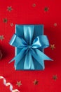 Christmas, party or birthday blue gift box or present with blue bow ribbon on red background Royalty Free Stock Photo