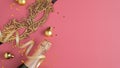 Christmas party concept. Golden ball decorations, carnival mask, champagne bottle, confetti on pink background. Flat lay, top view Royalty Free Stock Photo