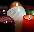 Christmas party, romantic date concept: colorful burning candles on dark background Royalty Free Stock Photo