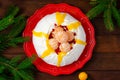 Christmas Pavlova cake with whipped cream, curd, tangerines and pomegranate on a dark wooden background. Copy space