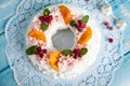 Christmas pavlova cake wreath decorated with cranberry, carmelized orange slices and mint