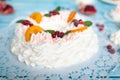 Christmas pavlova cake wreath decorated with cranberry, carmelized orange slices and mint