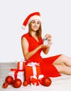 Christmas and people concept - smiling woman and alarm clock