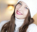 Christmas, people and winter holiday concept. Happy smiling woman wearing white knitted hat as closeup face xmas Royalty Free Stock Photo