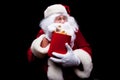 Christmas. Photo of Santa Claus gloved hand With a red bucket with popcorn, on a black background Royalty Free Stock Photo