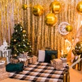 Christmas photo zone with a Christmas tree, garland, New Year`s decor and gifts. Christmas and New Year celebration concept