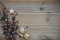 Christmas photography with silver and gold colored acorn tree ornament on natural rustic wood background with festive mince pies