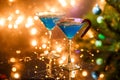 Christmas picture of two wine glasses with blue cocktail and garland