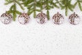 Christmas pink balls hanging on pink ribbon and tree branches on white background with small stars Royalty Free Stock Photo