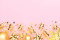 Christmas pink flatly. Many sparkling golden confetti, decorative snowflake and ribbons at pink background. Festive Royalty Free Stock Photo